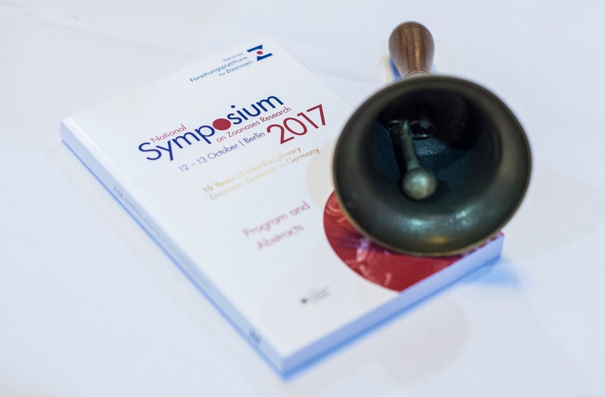 Programmbuch des Zoonosen-Symposiums 2017 und eine Glocke
