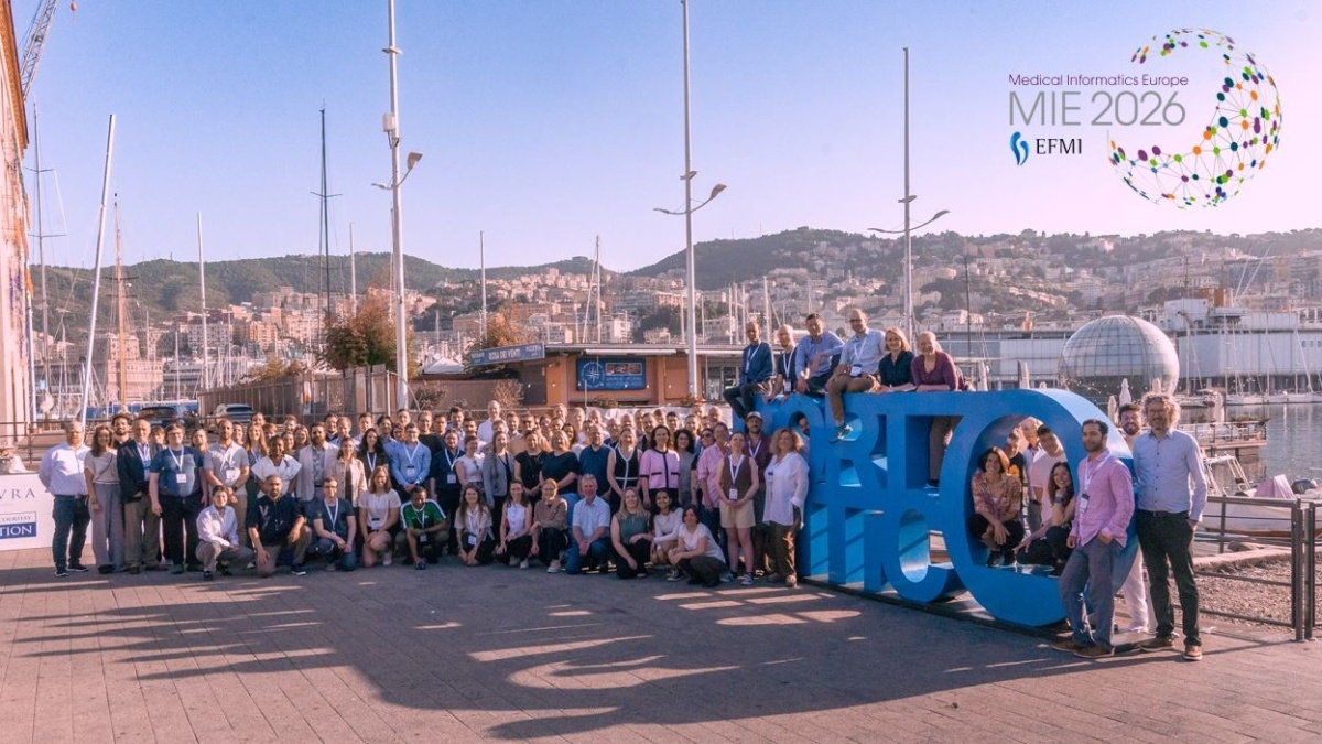 Eine große Ansammlung Menschen vor dem großen Text "Porto Antico" am Hafen in Genua.