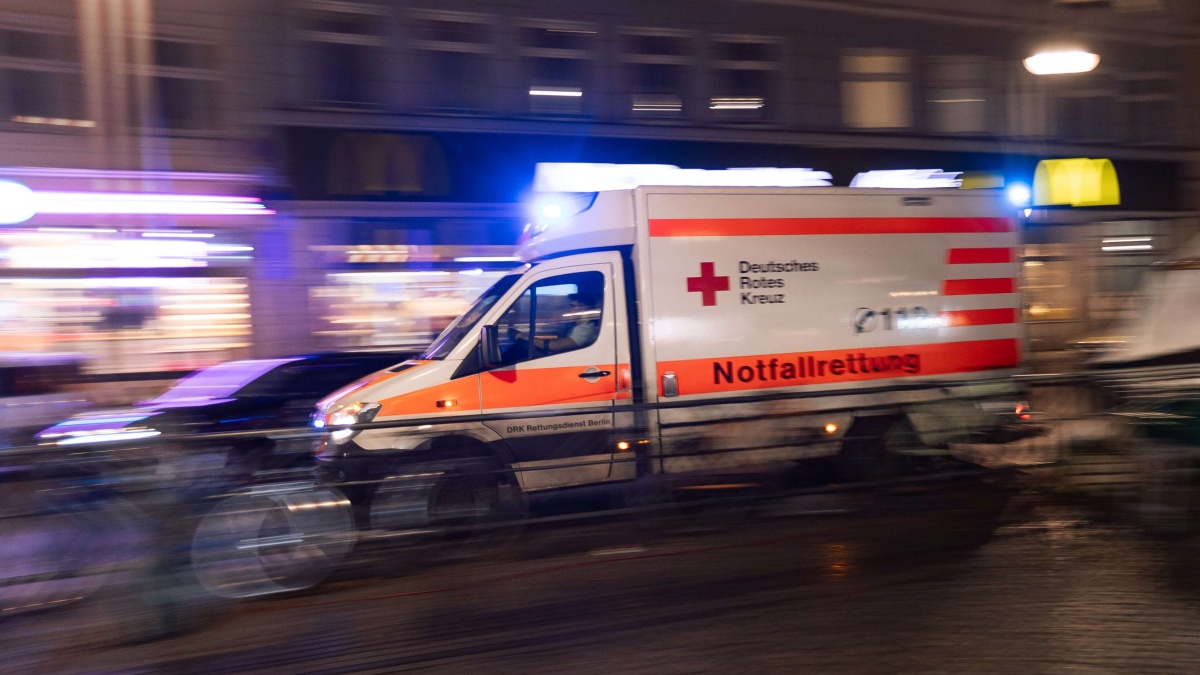 Ein Rettungswagen, der durch die Stadt fährt. Die Umgebung um ihn herum ist verschwommen.