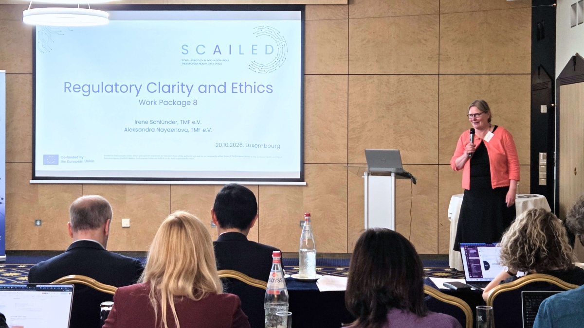 Irene Schlünder präsentiert beim SCAILED-Kick-off vor einem Publikum. Auf der Leinwand ist die Folie „Regulatory Clarity and Ethics – Work Package 8“ zu sehen, während die Teilnehmenden im Vordergrund der Präsentation folgen.