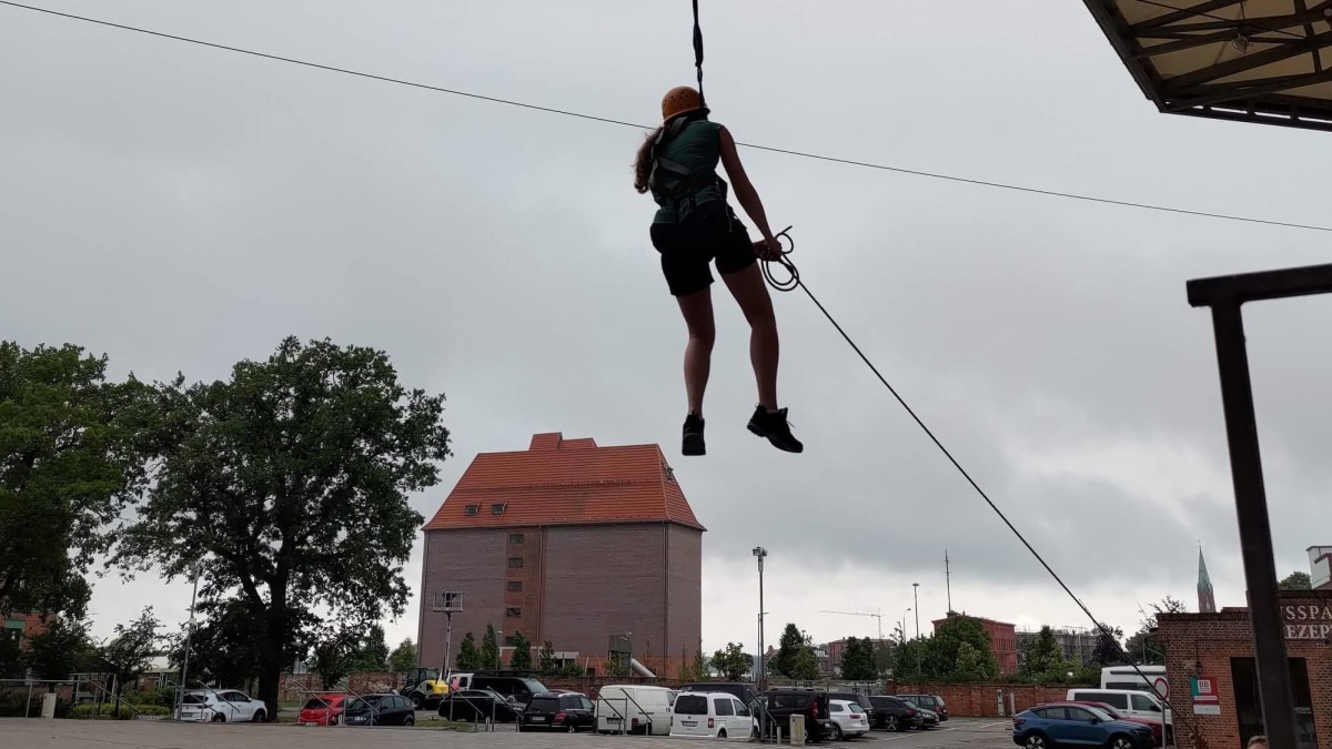 Eine Person in Kletterbekleidung an einem Seil in der Luft