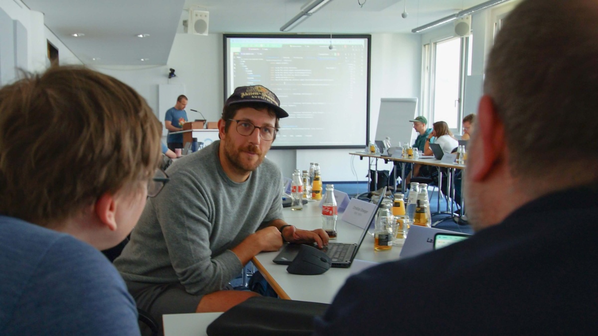 TMF-Mitarbeitender Dr. Philip Overton im Austausch mit zwei Workshop-Teilnehmenden.