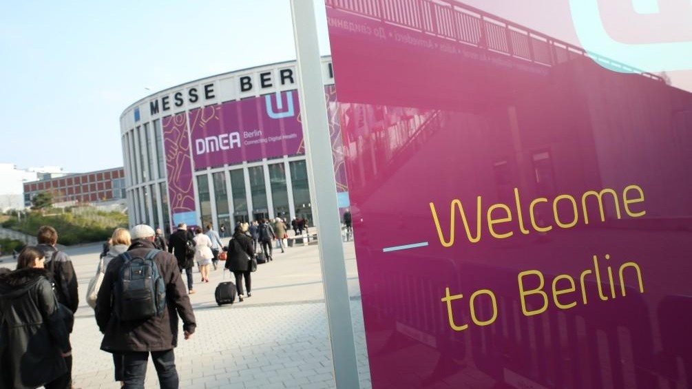The Messe Berlin from the outside. On the left, people can be seen walking toward the building; on the left, a banner reads “Welcome to Berlin.”