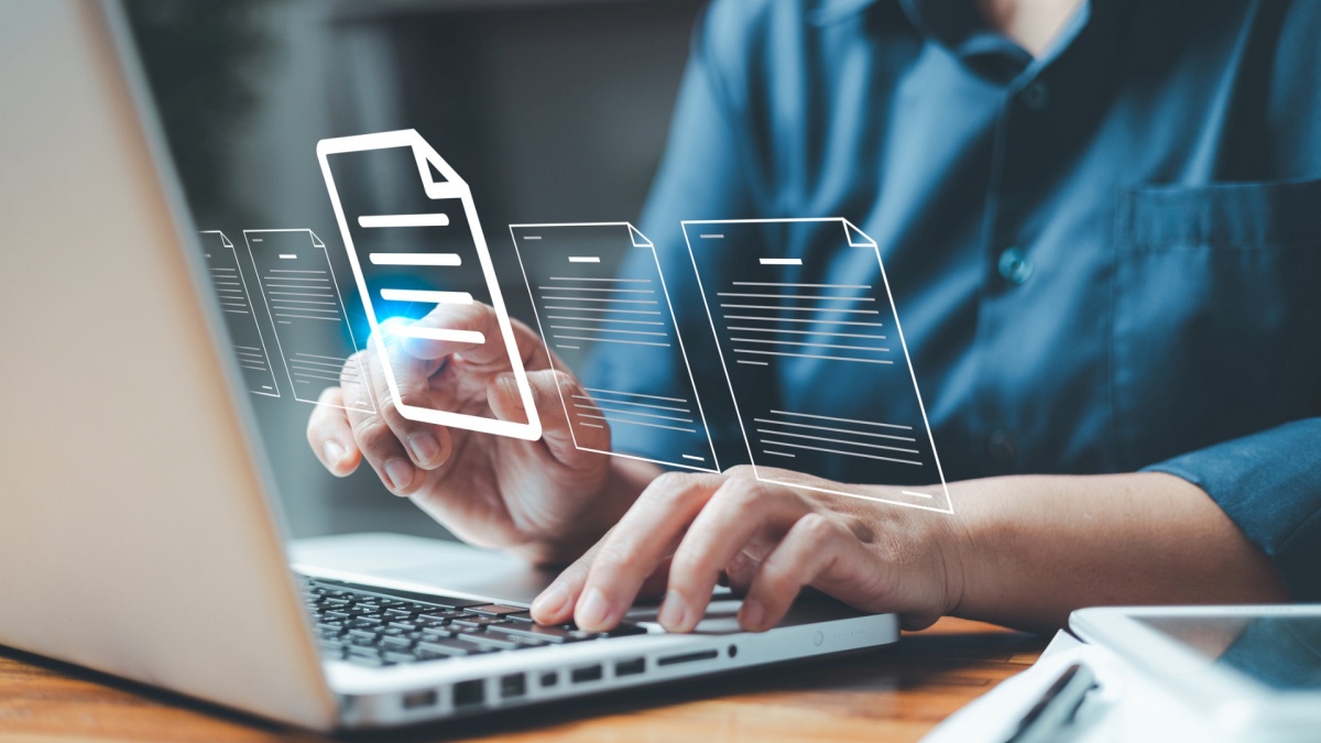 Person arbeitet am Laptop mit digital dargestellten Dokumenten – Symbolbild für digitales Dokumentenmanagement, Cloud-Speicherung, Datenverwaltung und papierlose Büroprozesse im modernen Arbeitsumfeld.