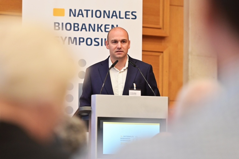 Dr. Ronny Baber spricht am Rednerpult beim Biobanken-Symposium 2026.