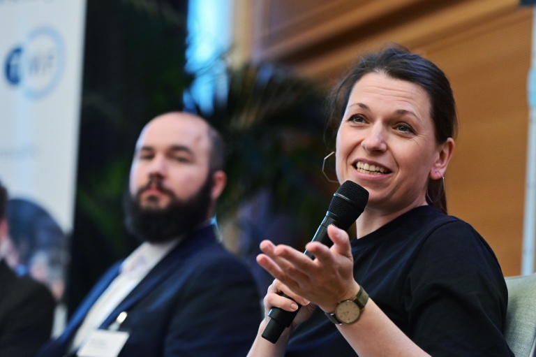 Ida Schönfeld mit einem Mikrofon während der Podiumsdiskussion der Industrie-Session beim Biobanken-Symposium 2026.