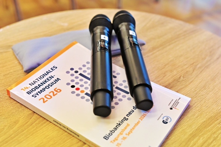 Zwei Handmikrofone auf dem Tagungsband des Nationalen Biobanken-Symposiums 2026.