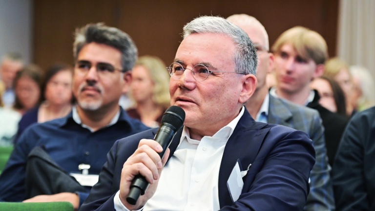 PD Dr. Dr. Michael Kiehntopf mit einem Mikrofon während des Biobanken-Symposiums 2026.