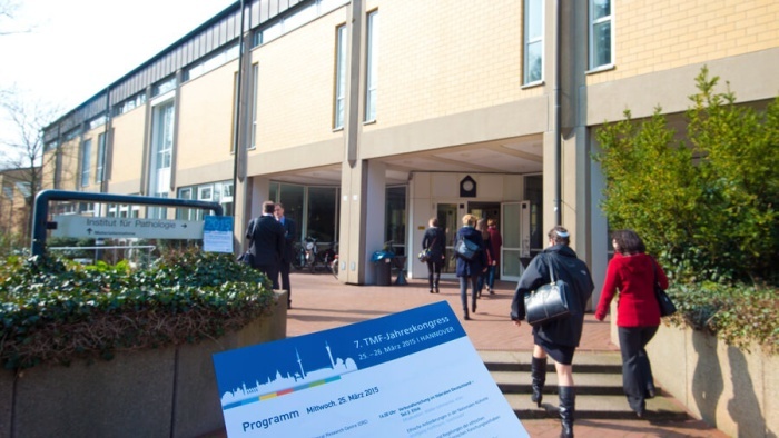 Der Eingangsbereich zum TMF-Jahreskongress 2015 und ein Ausschnitt des Flyers