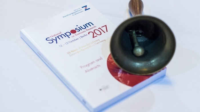 Programmbuch des Zoonosen-Symposiums 2017 und eine Glocke