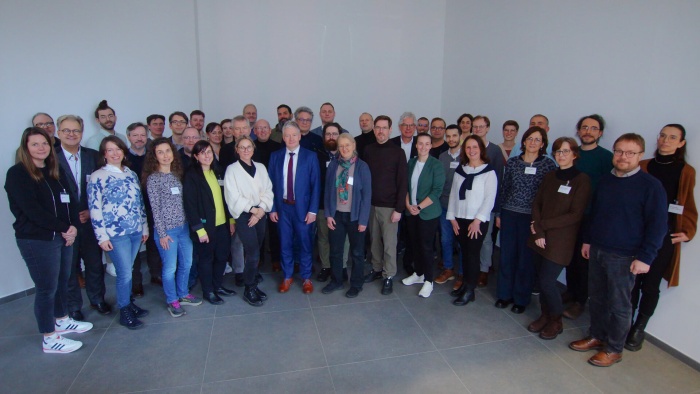Gruppenfoto mit 41 Personen anlässlich des Kick-offs der Digitalen FortschrittHubs Gesundheit. Die Personen stehen in mehreren Reihen nebeneinander, überwiegend in Business- oder Smart-Casual-Kleidung, einige mit Namensschildern.