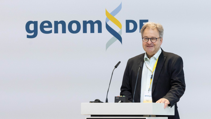 TMF-Geschäftsführer Sebastian C. Semler vor einem Rednerpult mit dem genomDE-Logo im Hintergrund.