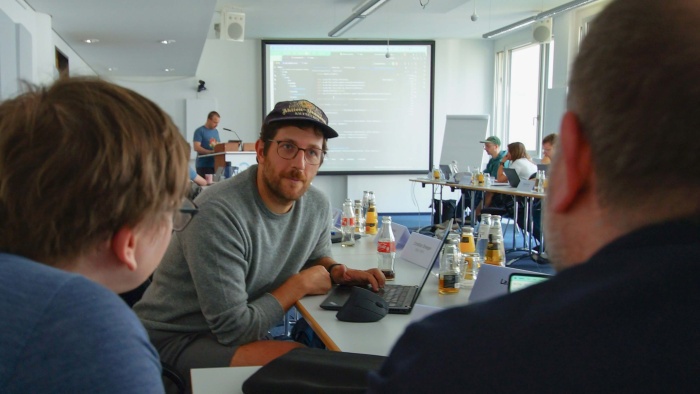 TMF-Mitarbeitender Dr. Philip Overton im Austausch mit zwei Workshop-Teilnehmenden.