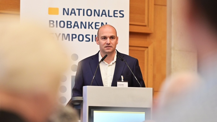 Dr. Ronny Baber spricht am Rednerpult beim Biobanken-Symposium 2026.