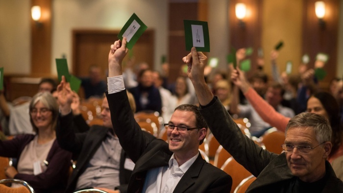 Teilnehmer und Teilnehmerinnen des Zoonosen-Symposiums 2015, die Zettel in die Höhe halten