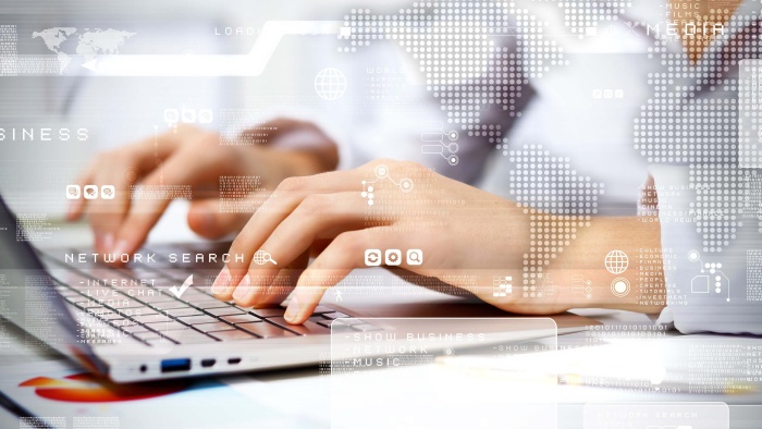 Hände tippen auf einem Laptop. Darüber sind digitale Netzwerk- und Weltkarten-Grafiken als Symbol für globale Vernetzung, Datenverarbeitung und digitale Kommunikation eingeblendet.
